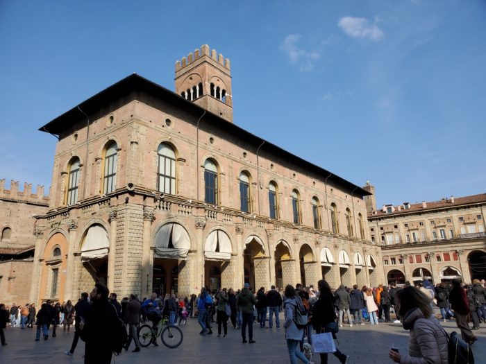 Photo of a crowded square and buildings in Bologna, Italy
