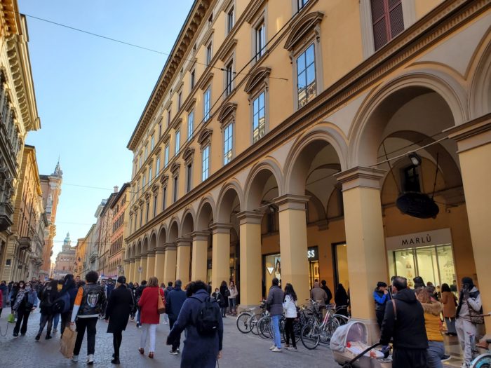 Photo of a crowded street and buildings in Bologna, Italy